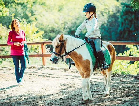 Ein Kind lernt Reiten